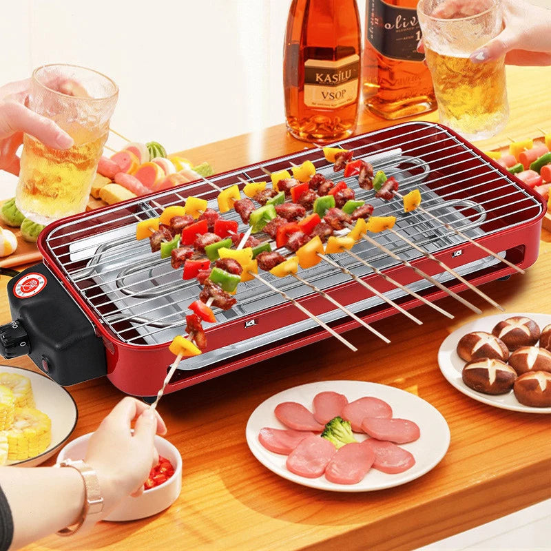 Grill Electrique Rouge Design et Multifonctionnel, avec plein de brochettes dessus, positionné sur une table.